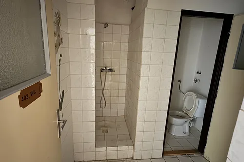 Společná umývárna se sprchou a oddělenou kabinkou WC v podkroví domu Hlinky 28a, srpen 2025
