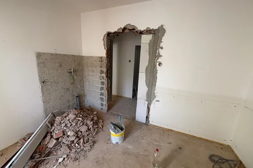 Podkrovní pokoj při bourání, nový otvor ve zdi a suť na podlaze, Hlinky 28a, srpen 2025