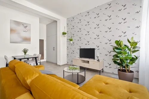 Apartmán s hořčicovou pohovkou a tapetou s jeřáby, červenec 2023