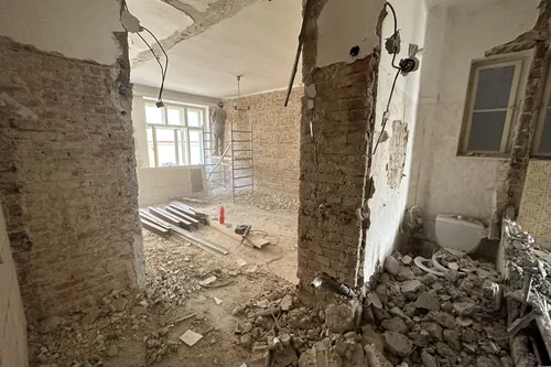 Byt při stavební rekonstrukci, cihlové pilíře a suť na podlaze, květen 2023