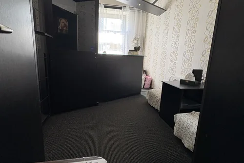 Původní recepce hotelu s tmavým pultem a tapetou, červen 2025
