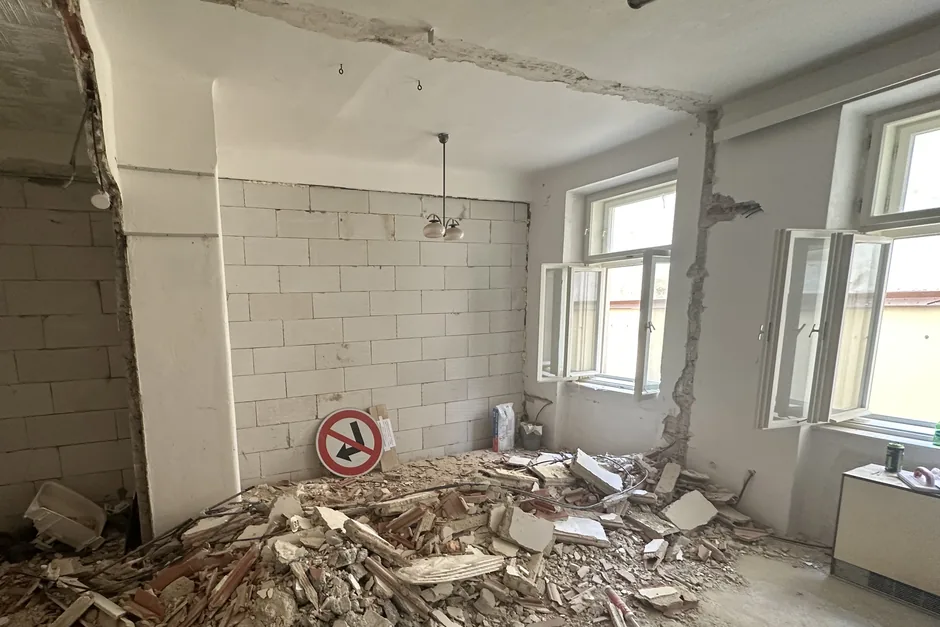 Před rekonstrukcí: byt do dvora po vybourání koupelny, suť na podlaze, květen 2023